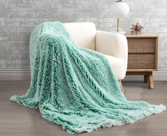 Emerald faux fur shaggy throw blanket draped over a cream chair, adding luxury and warmth to a cozy room setting.