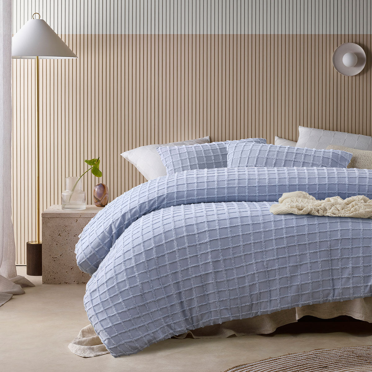 Lifestyle shot of the blue quilt cover set styled in a cozy bedroom, featuring matching pillowcases and a neutral color palette for a warm ambiance.