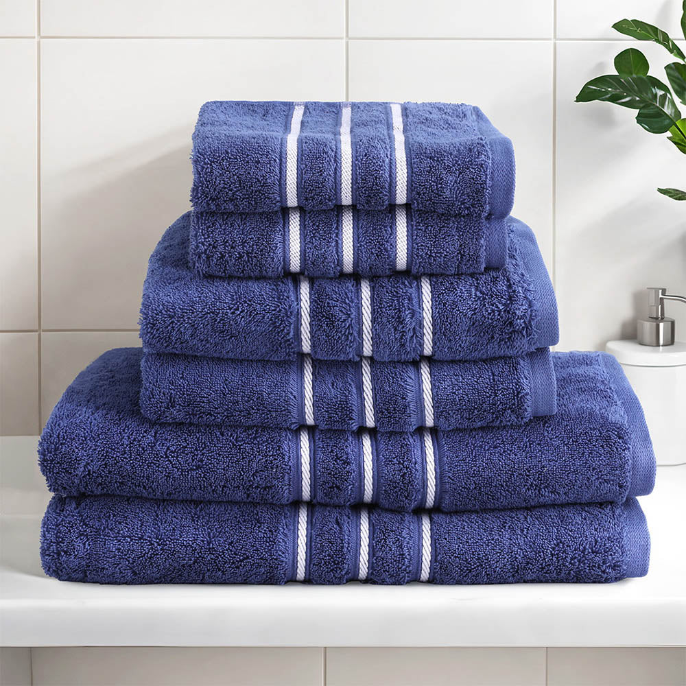 Luxury navy cotton bath towel set stacked on a shelf, featuring plush texture and elegant stripe design for a stylish bathroom.