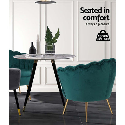 Elegant green velvet accent chair at a dining table, showcasing luxury and comfort in modern interior design.