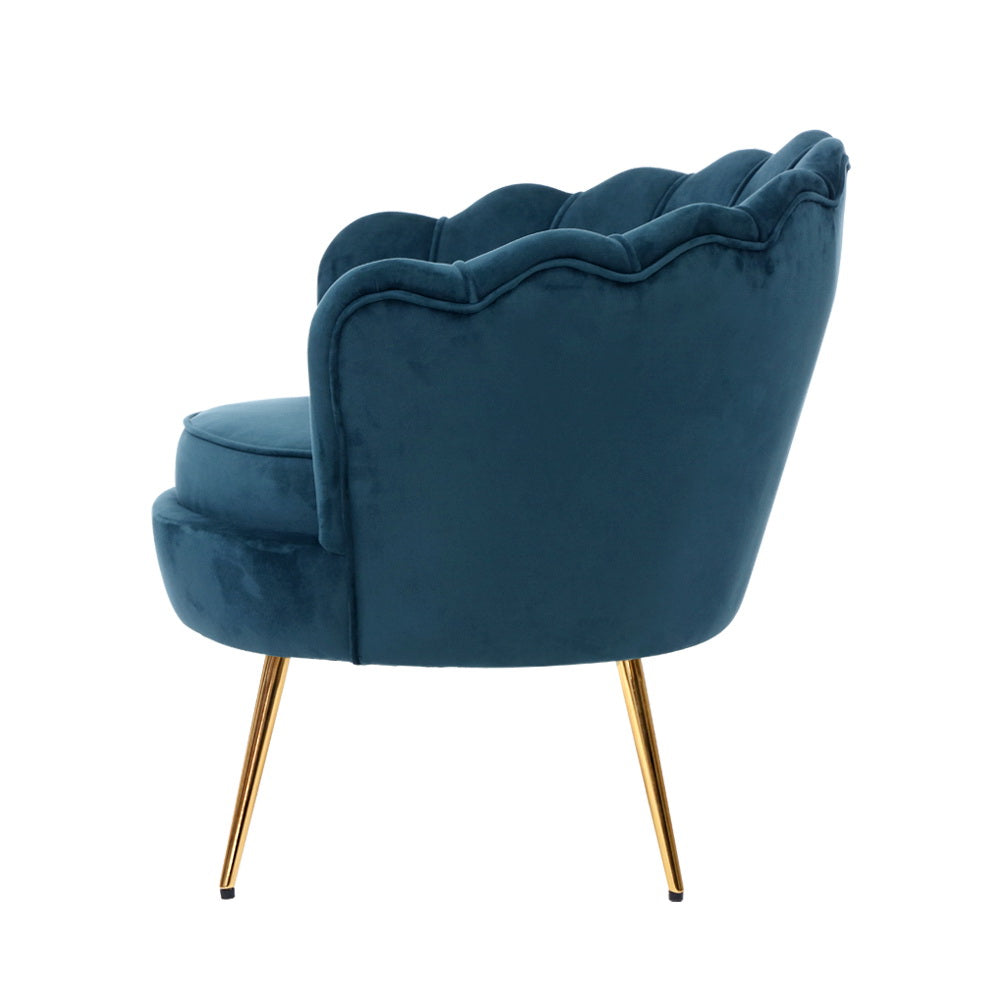 Elegant blue velvet accent chair with gold legs, featuring a stylish scalloped back design and a luxurious touch for any room.