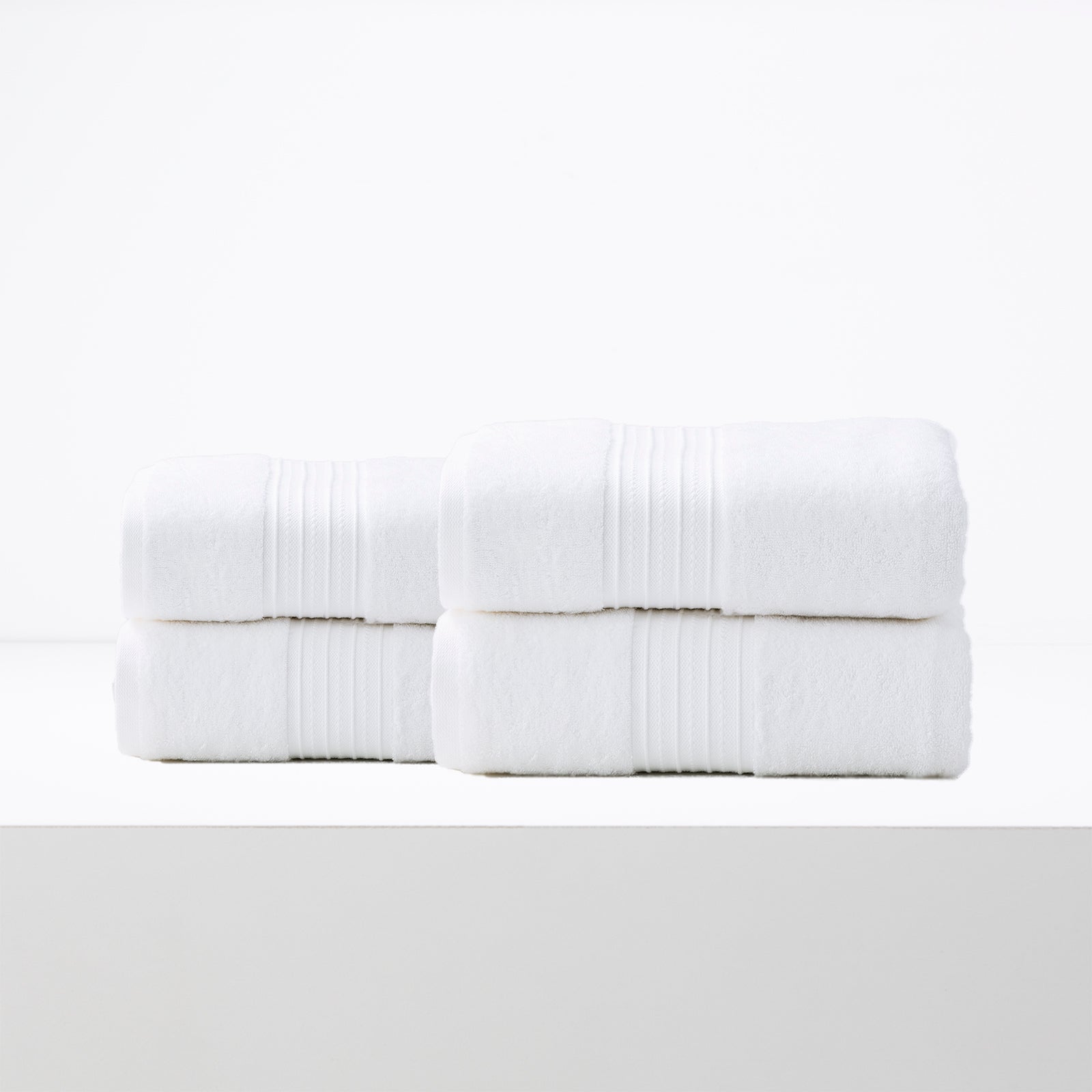 Bright white bath sheet set of four made from soft low-twist cotton, perfect luxury towels for quick drying and all-season use.