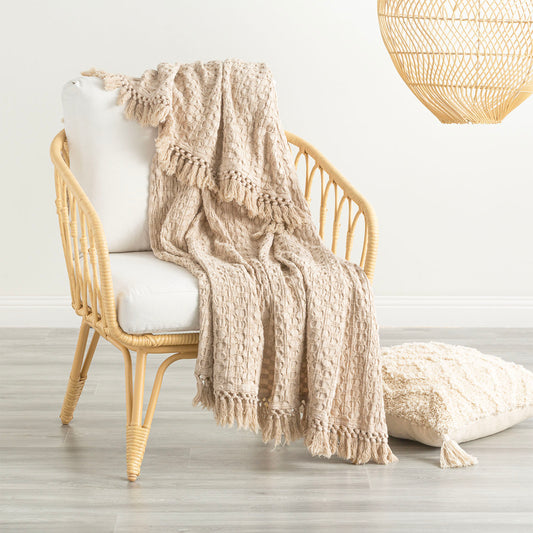 Alysian Washed Cotton Textured Sand Throw draped over a stylish chair, showcasing its plush texture and crochet fringe detail.