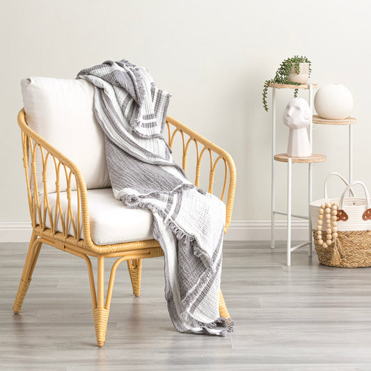 Ray Striped vintage washed cotton throw blanket draped over a chair, adding a stylish touch to modern decor.