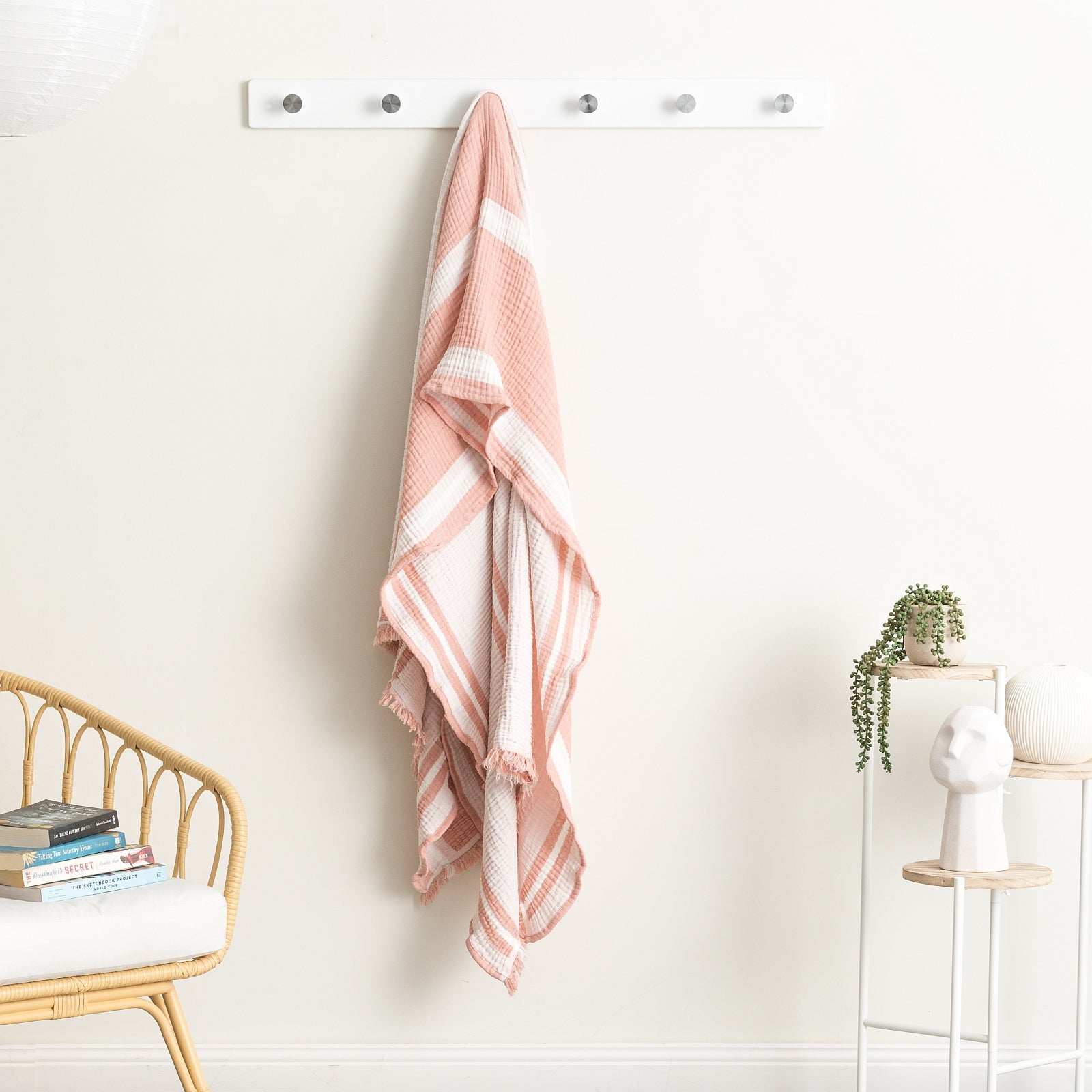 Ray Striped vintage washed throw blanket hanging on a wall hook, showcasing modern stripes and soft cotton texture.