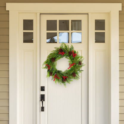 Festive Christmas wreath with pine cones and red berries adorning a front door, perfect for holiday celebrations.