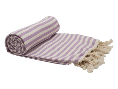 Portsea Turkish cotton beach towel in lilac and cream stripes, rolled up with tassels, perfect for beach days.