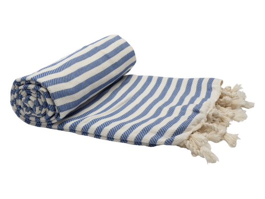 Rolled Portsea Turkish cotton beach towel in denim and cream stripes with tassels, perfect for a day on the beach.