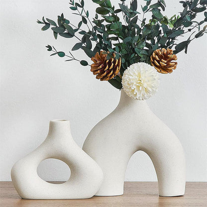 Set of 2 modern white ceramic vases with flowers and pine cones, perfect for stylish home decor and plant display.