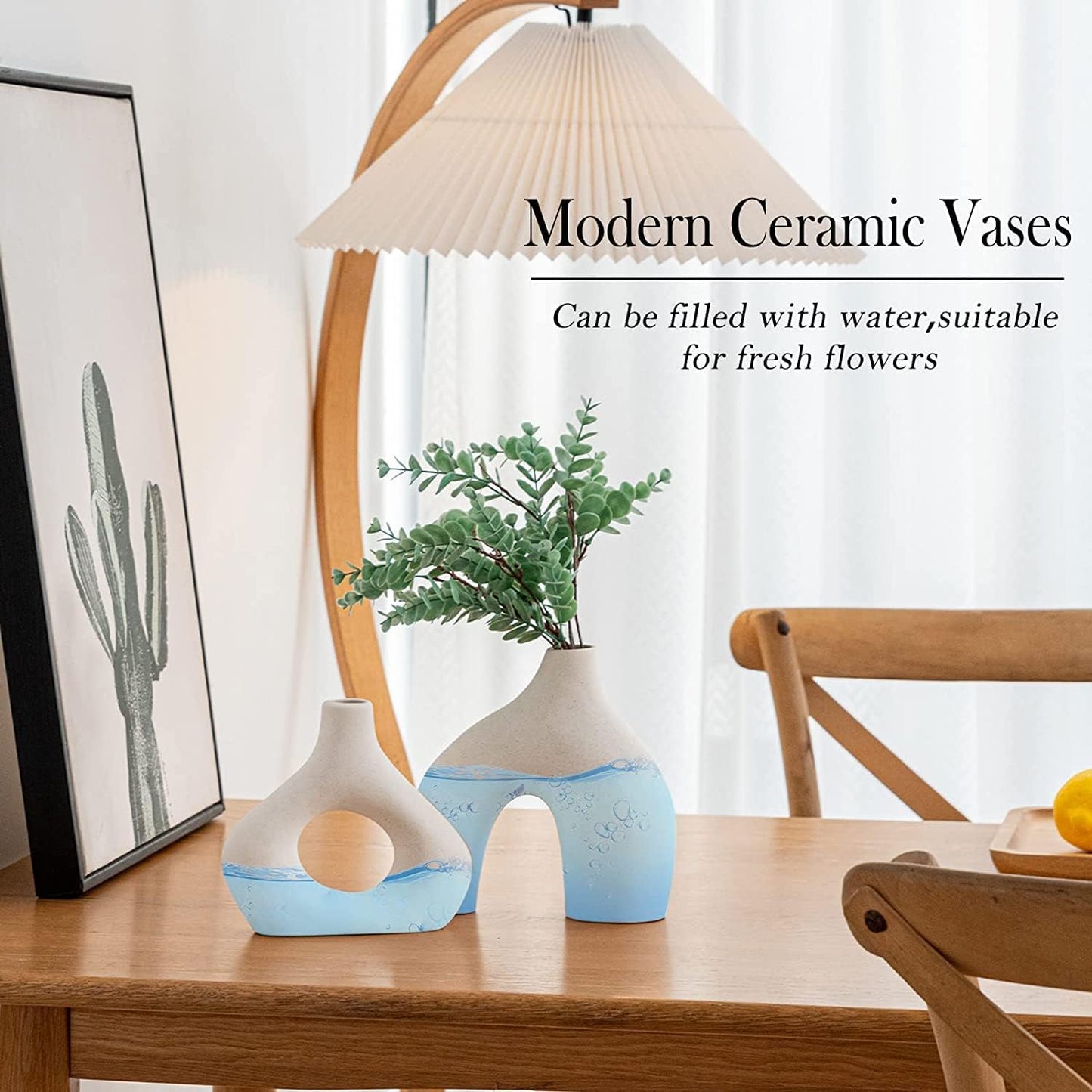 Modern ceramic vases with greenery, perfect for fresh flowers and stylish home decor on a wooden table.