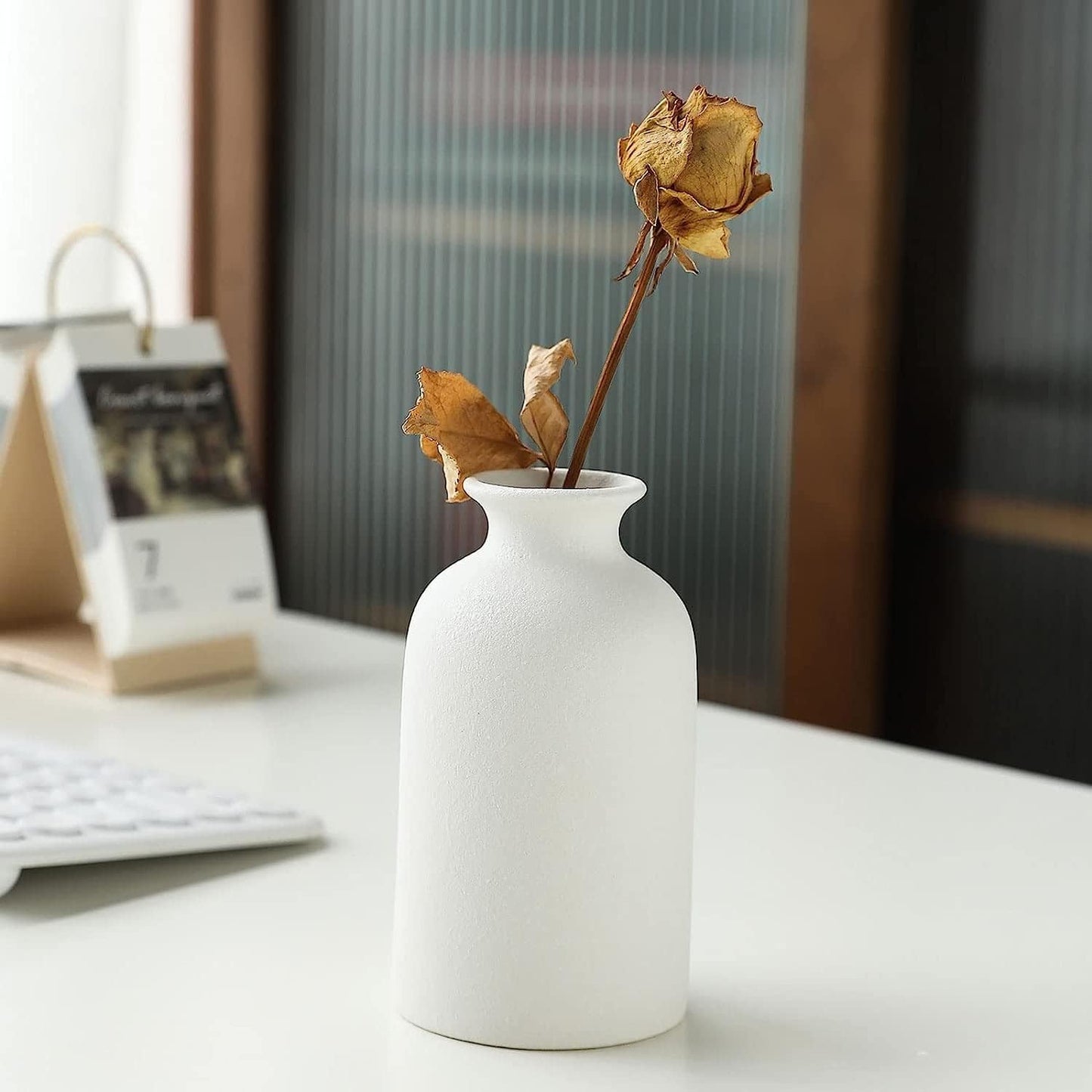 Modern Nordic ceramic vase in matte white displaying dried flowers for minimalist home decor.