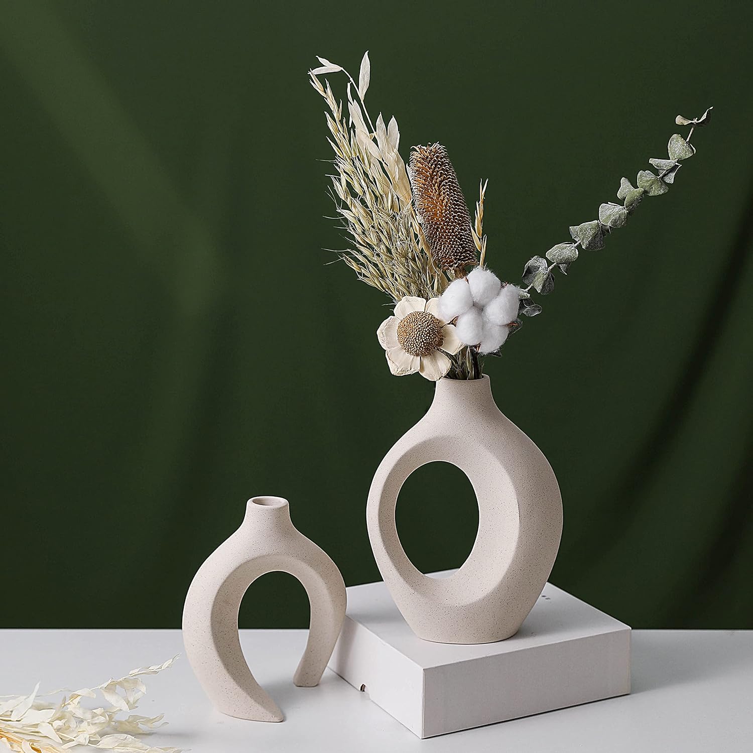 Creative white ceramic vases with dried flowers, perfect for stylish home decor and rustic elegance.