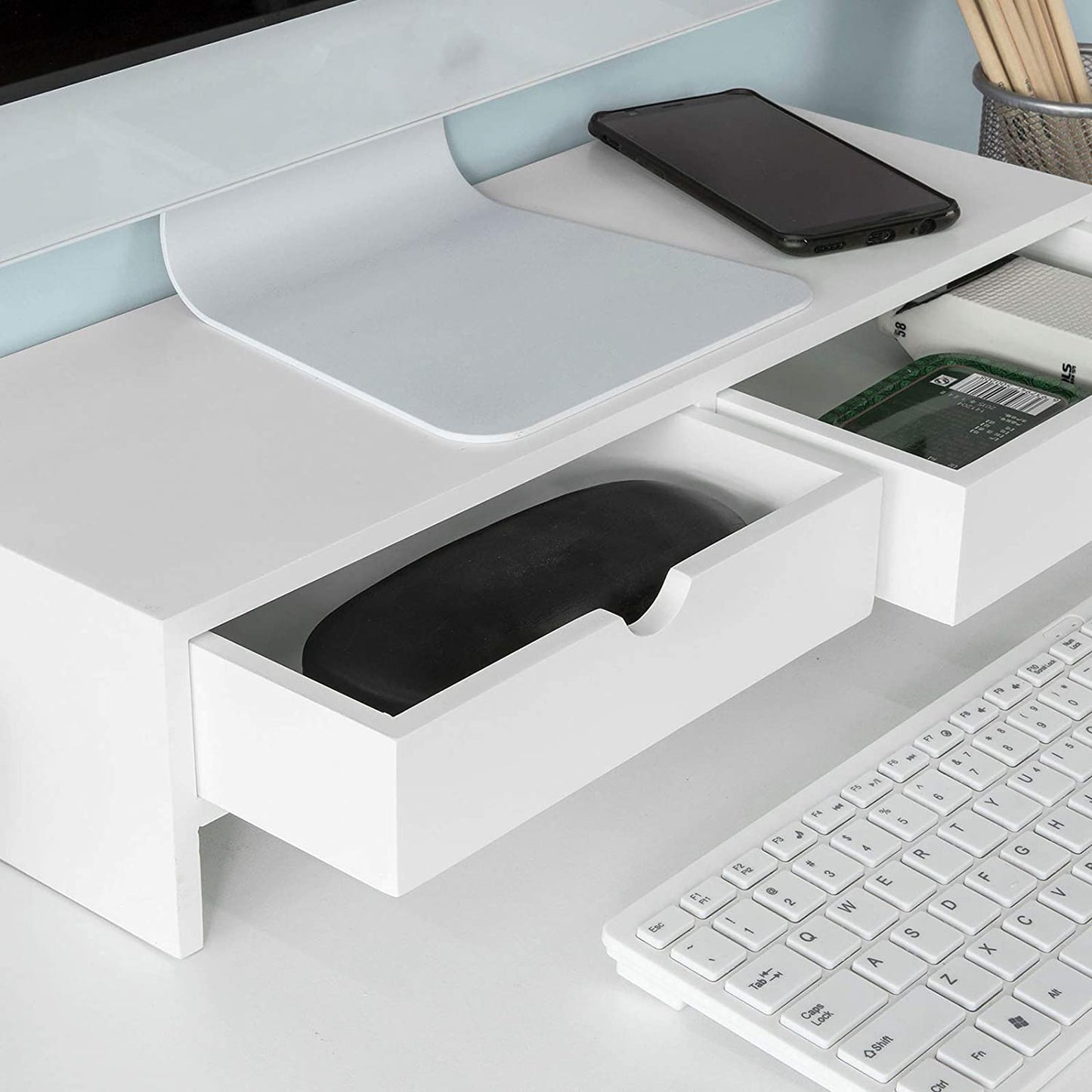 White monitor stand desk organizer with two drawers, compact keyboard, and storage space for gadgets.