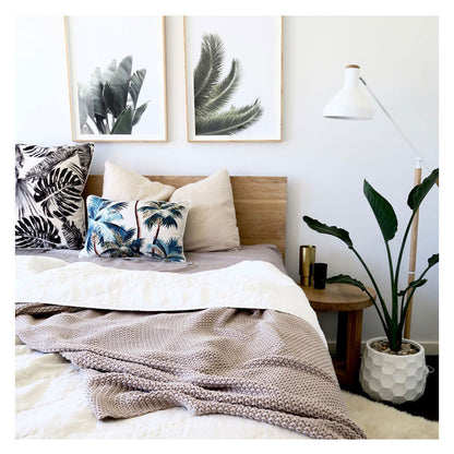 Stylish bedroom featuring palm tree cushion cover and tropical decor for a modern, relaxed vibe.