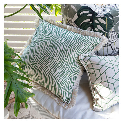 Decorative green cushion cover with textured pattern and fringed edges, perfect for indoor or outdoor decor.