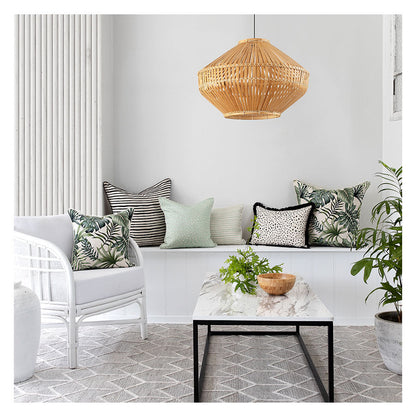 Cozy living space featuring tropical cushion covers on a bench and a stylish rattan pendant lamp. Perfect for indoor or outdoor decor.