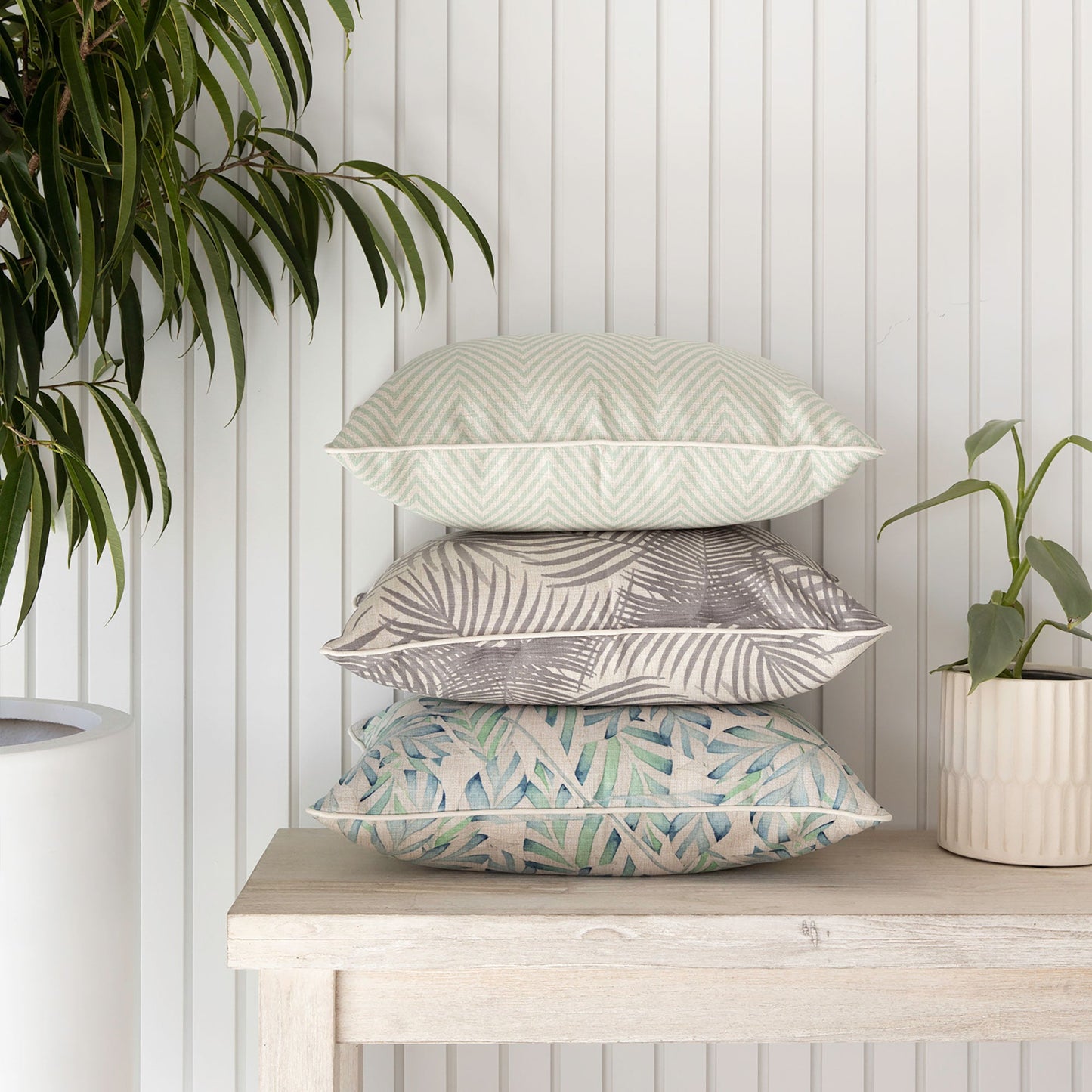 Stylish stack of cushion covers in tropical patterns, perfect for enhancing your sofa or couch decor.