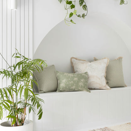 Decorative cushion covers in soft green and cream on a serene bench, enhancing a tropical home ambiance.