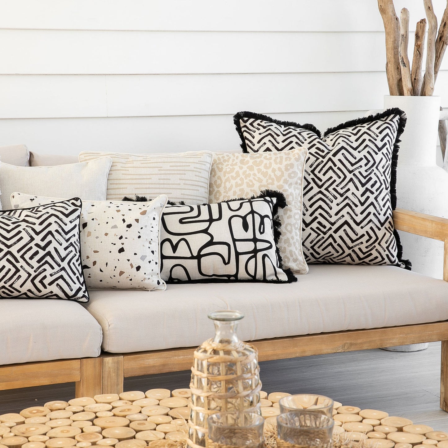 Stylish couch with various decorative cushion covers in black and white patterns for a modern living space.