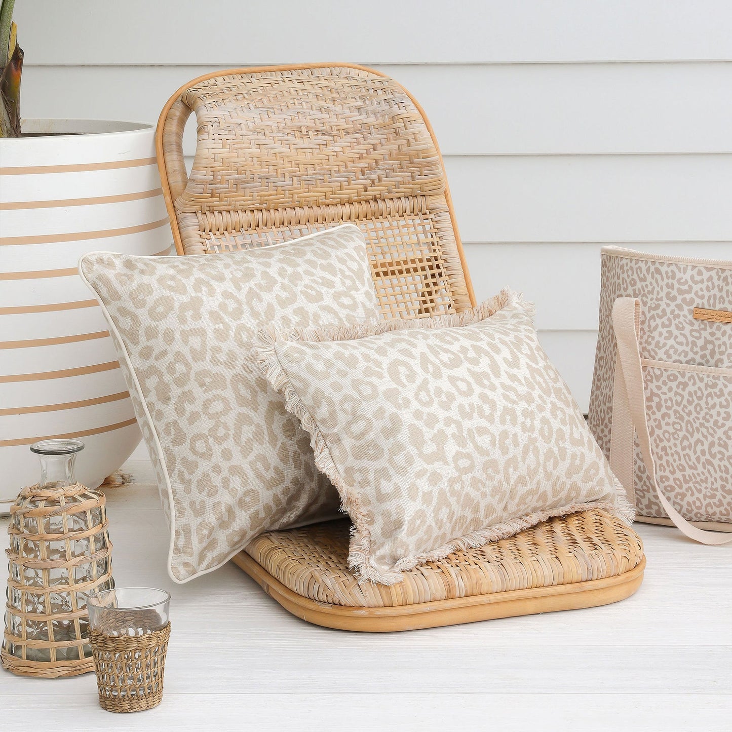 Two leopard print cushion covers on a rattan chair, perfect for adding a tropical touch to your home decor.