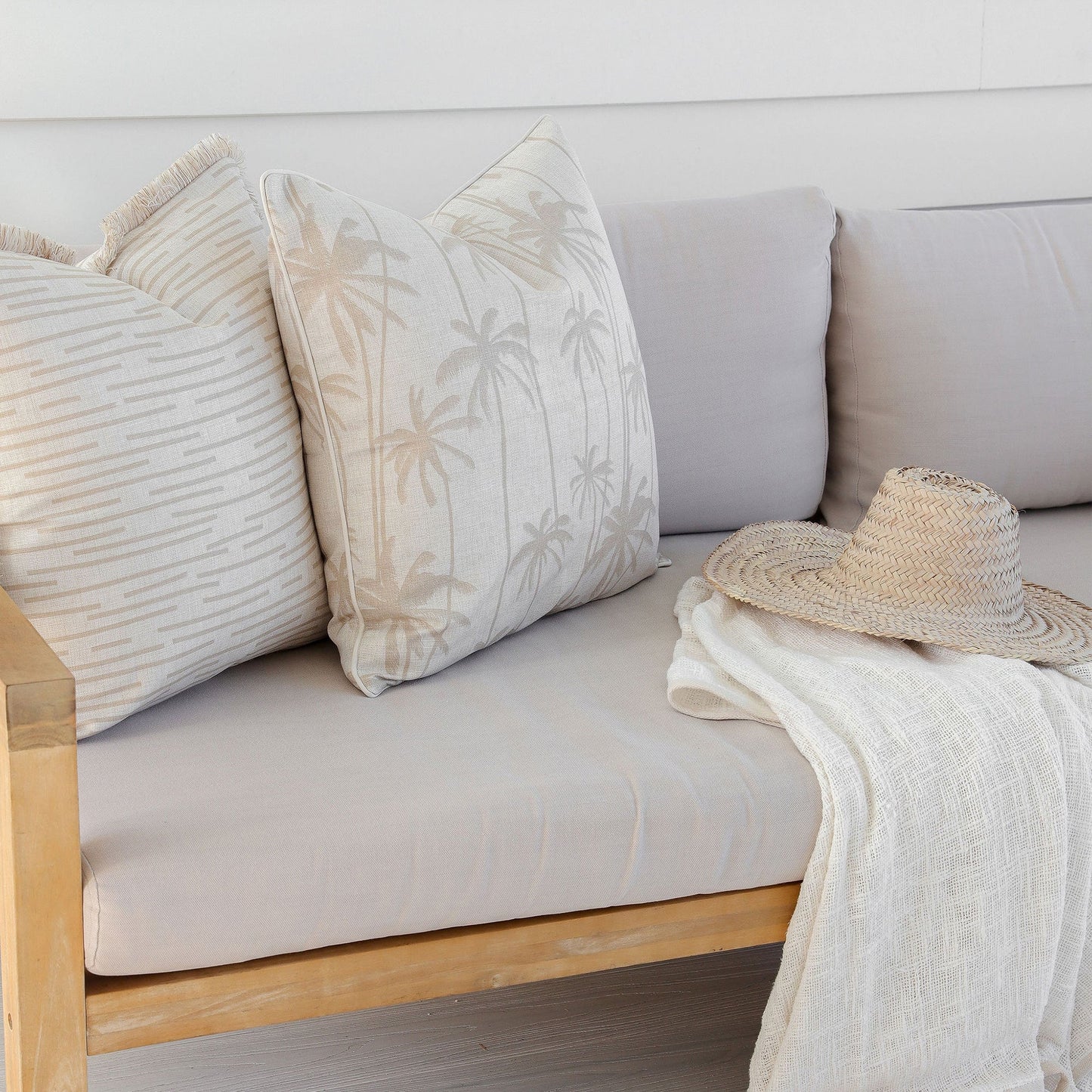 Stylish beige cushion covers with palm print and textured fabric on a cozy sofa, perfect for tropical home decor.