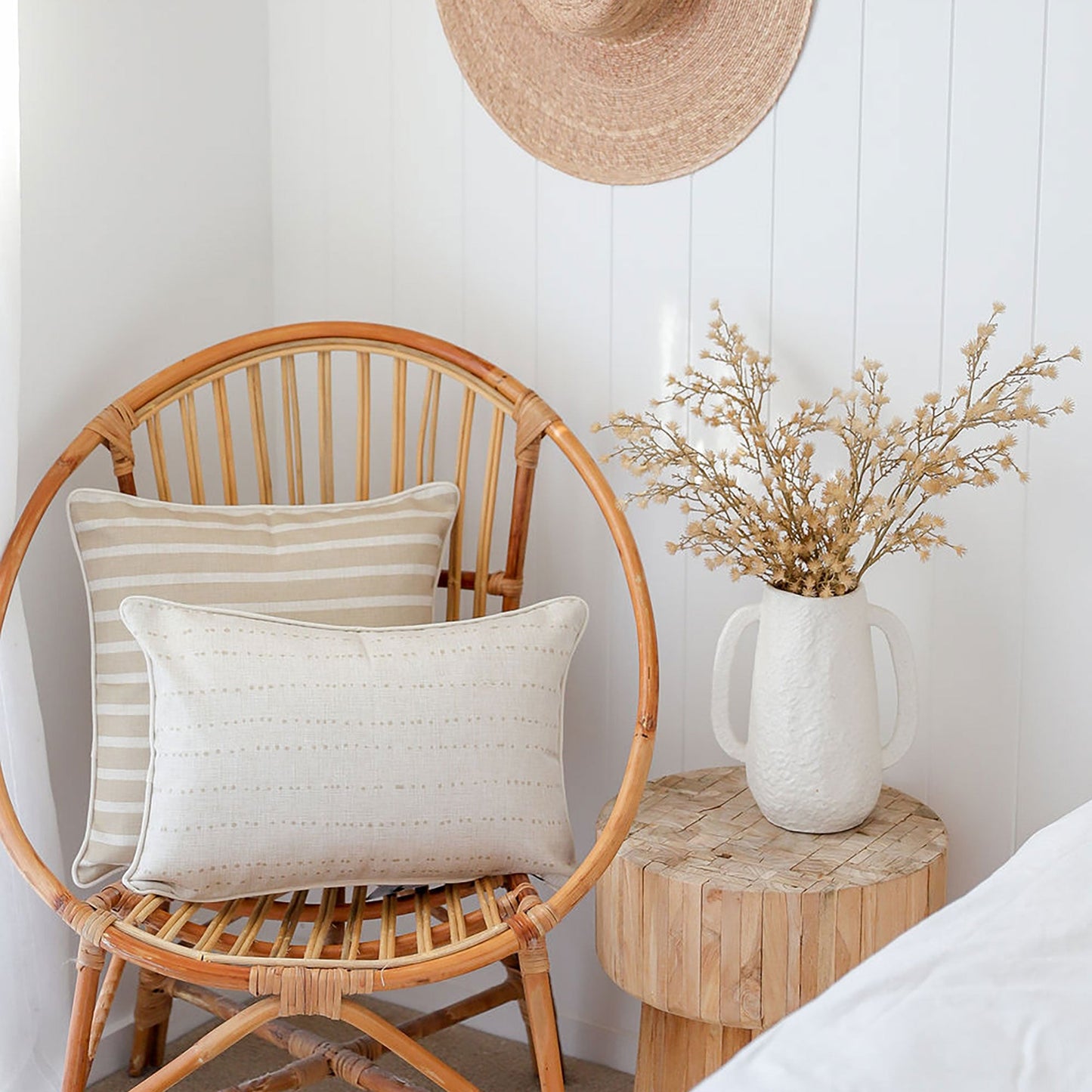 Stylish cushion covers on a rattan chair, enhancing tropical decor with beige tones and textured designs.