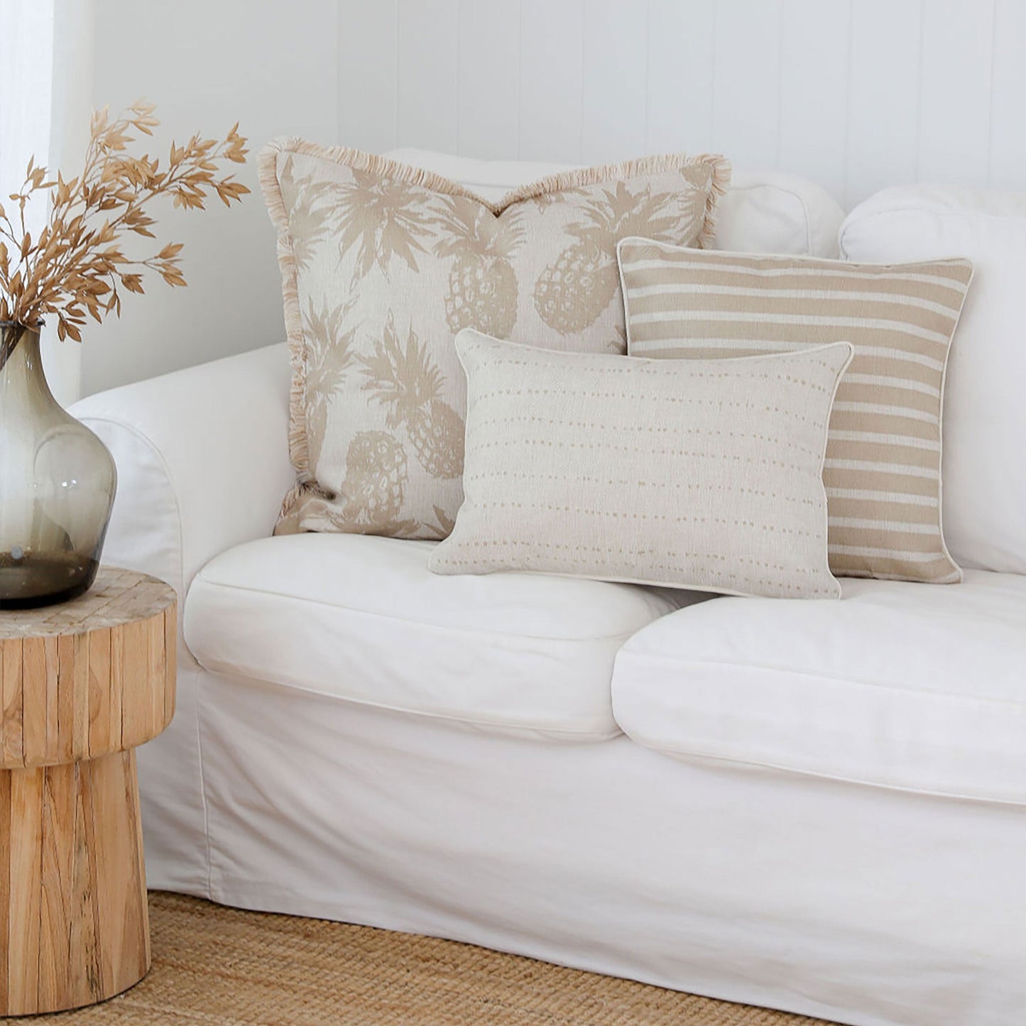 Stylish couch with beige cushion covers featuring striped and patterned designs, enhancing a cozy living space.