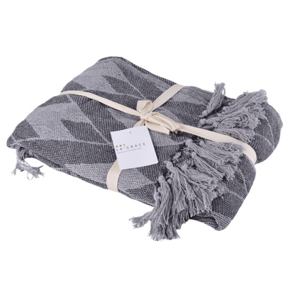 Soft cotton handloom throw blanket in grey with herringbone pattern and tassels, perfect for sofas and beds.