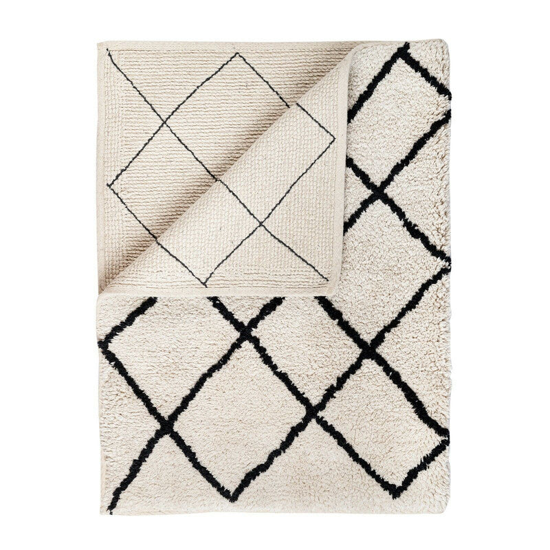 Soft cotton bath rug with tufted jacquard design in cream and black, perfect for adding style to any bathroom.