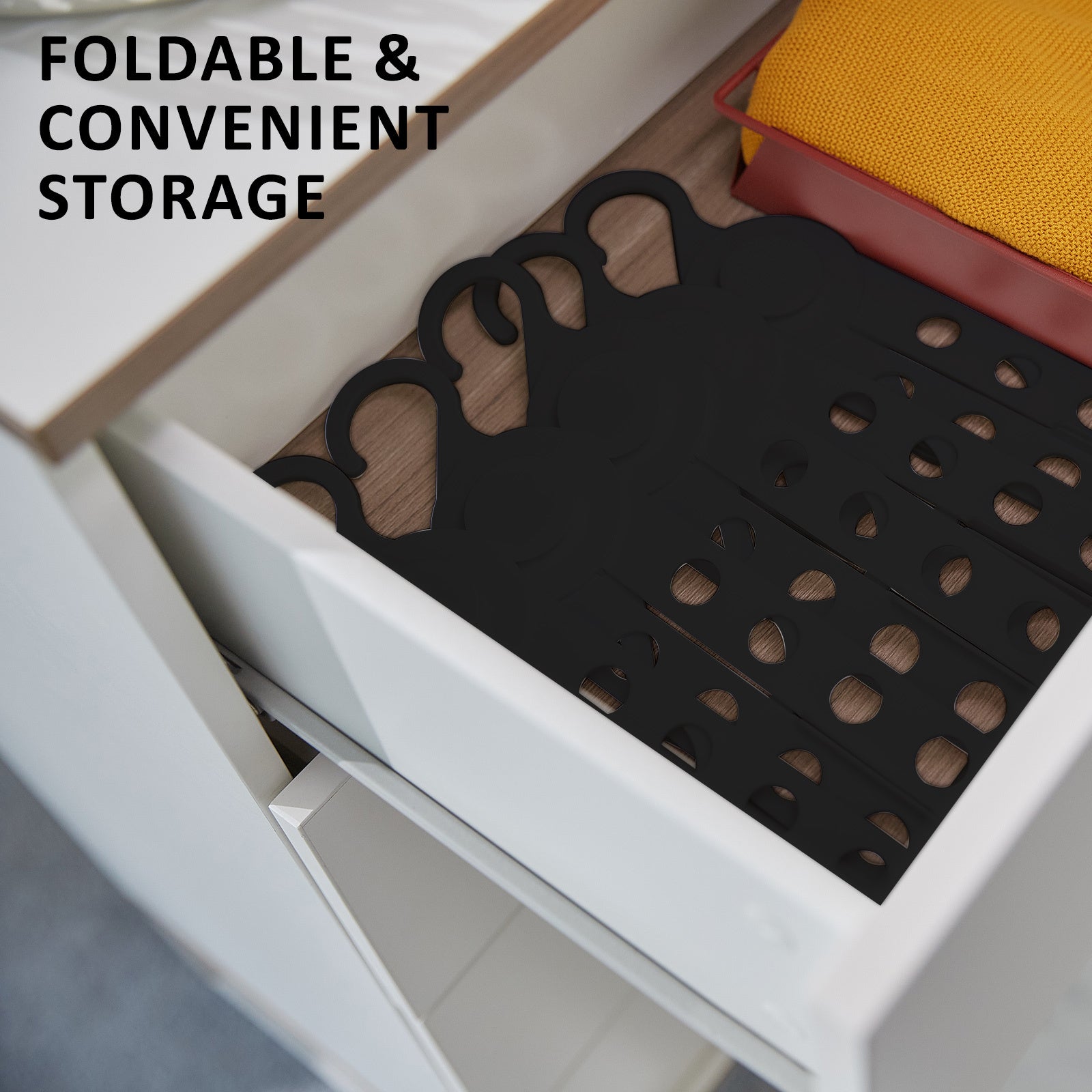 Foldable black coathangers neatly stored in a drawer for convenient clothes storage and organization.