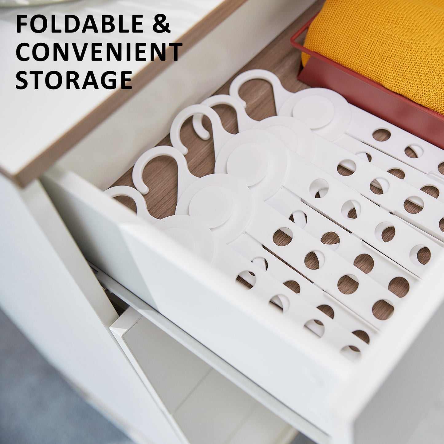 Foldable white coathangers organized neatly in a drawer for convenient clothes storage.