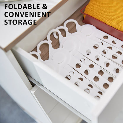 Foldable white coathangers organized neatly in a drawer for convenient clothes storage.