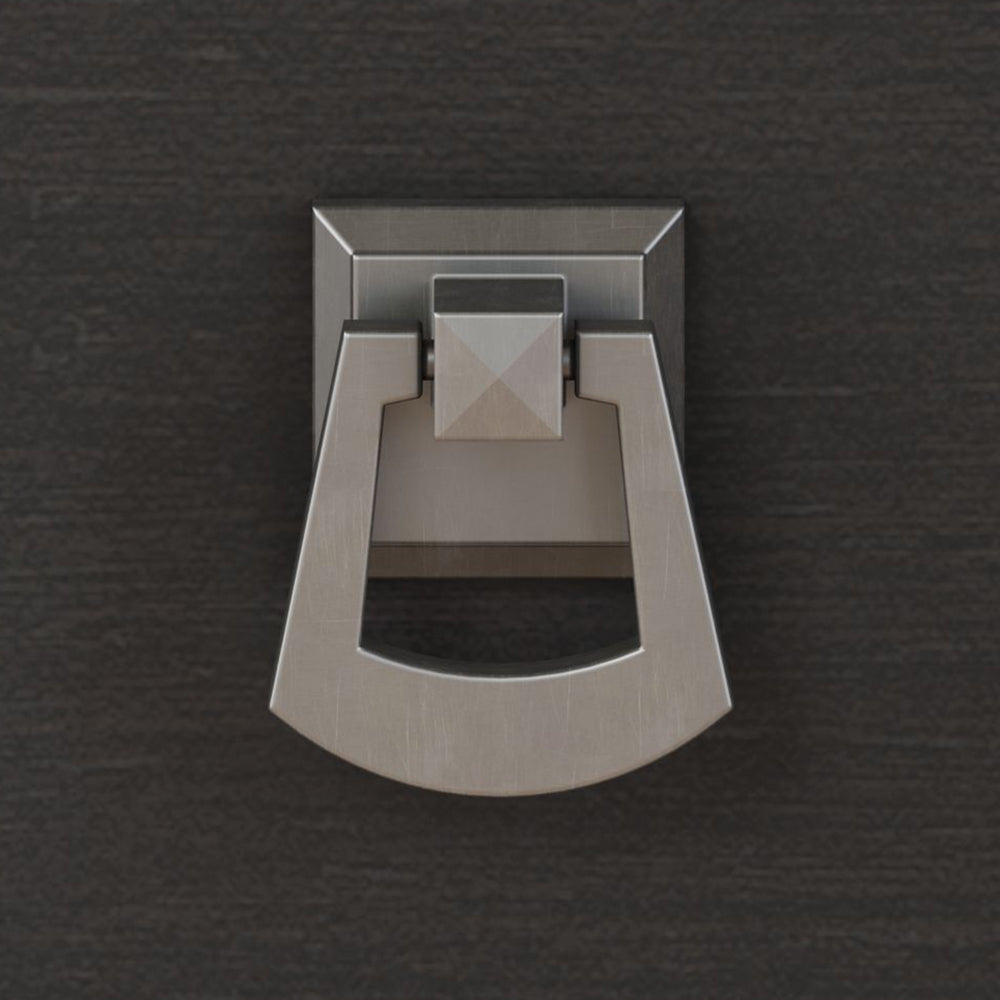 Close-up of a modern metal drawer pull with a square backplate and curved handle on a dark wood background.