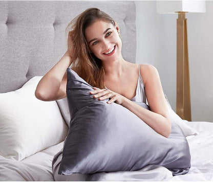 Woman enjoying a luxury mulberry silk pillowcase in charcoal color for a silky sleep experience.