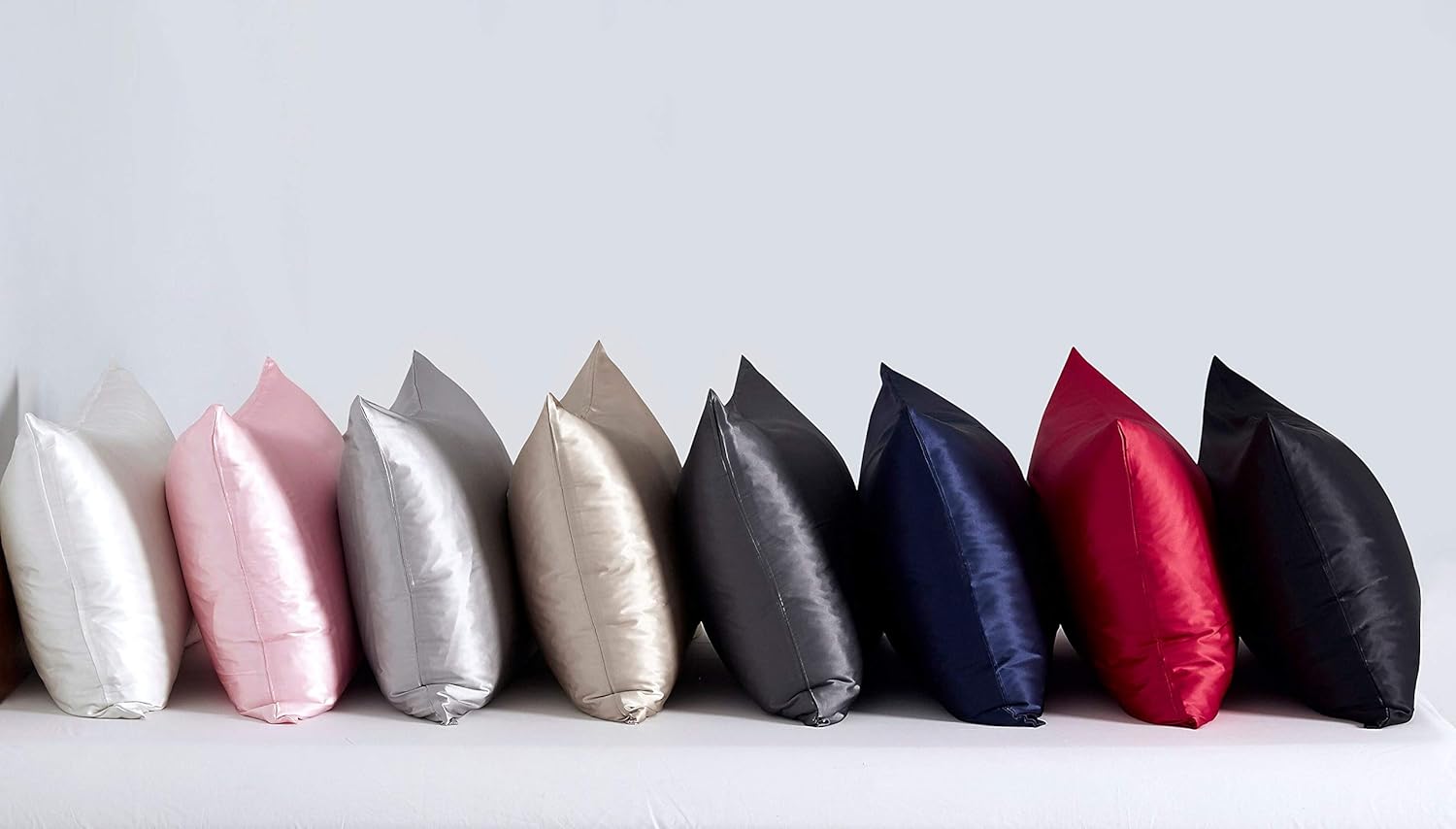 Luxurious silk pillowcases in various colors including pink, silver, charcoal, navy, and red, showcasing premium quality and style.