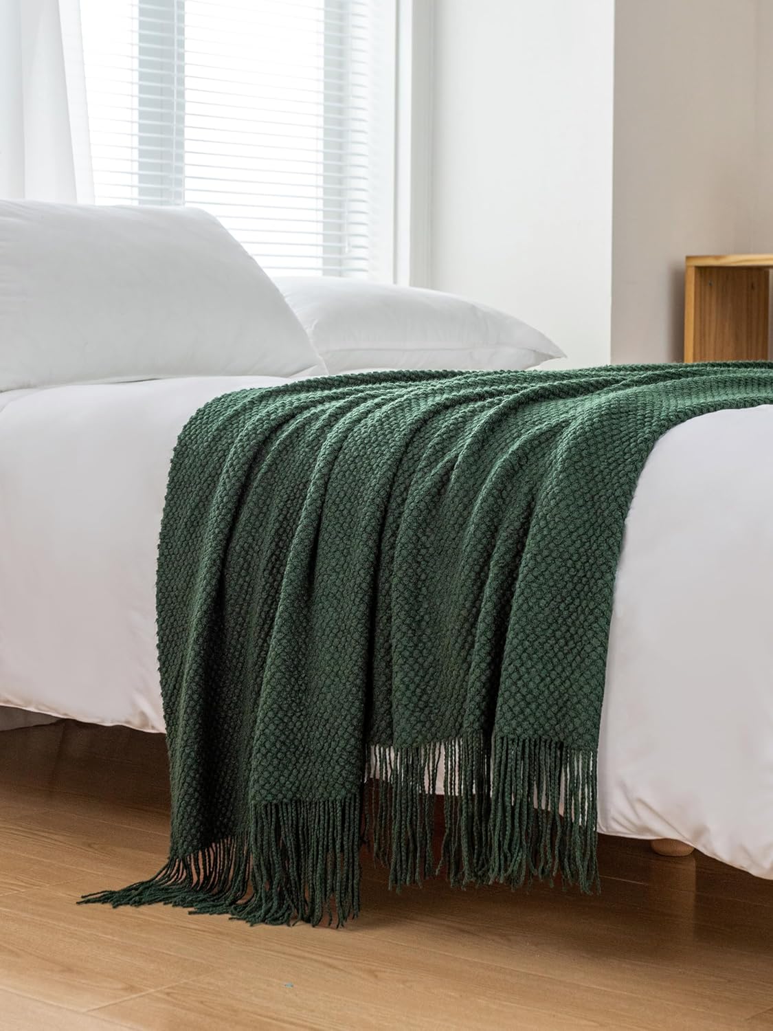 Forest green micro plush knitted woven throw blanket elegantly draped over a bed, perfect for cozy warmth and style.