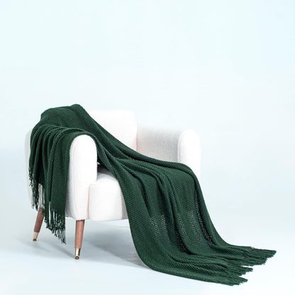 Forest green micro plush throw blanket draped over a white chair, showcasing its soft knitted design. Perfect for couches, sofas, and beds.