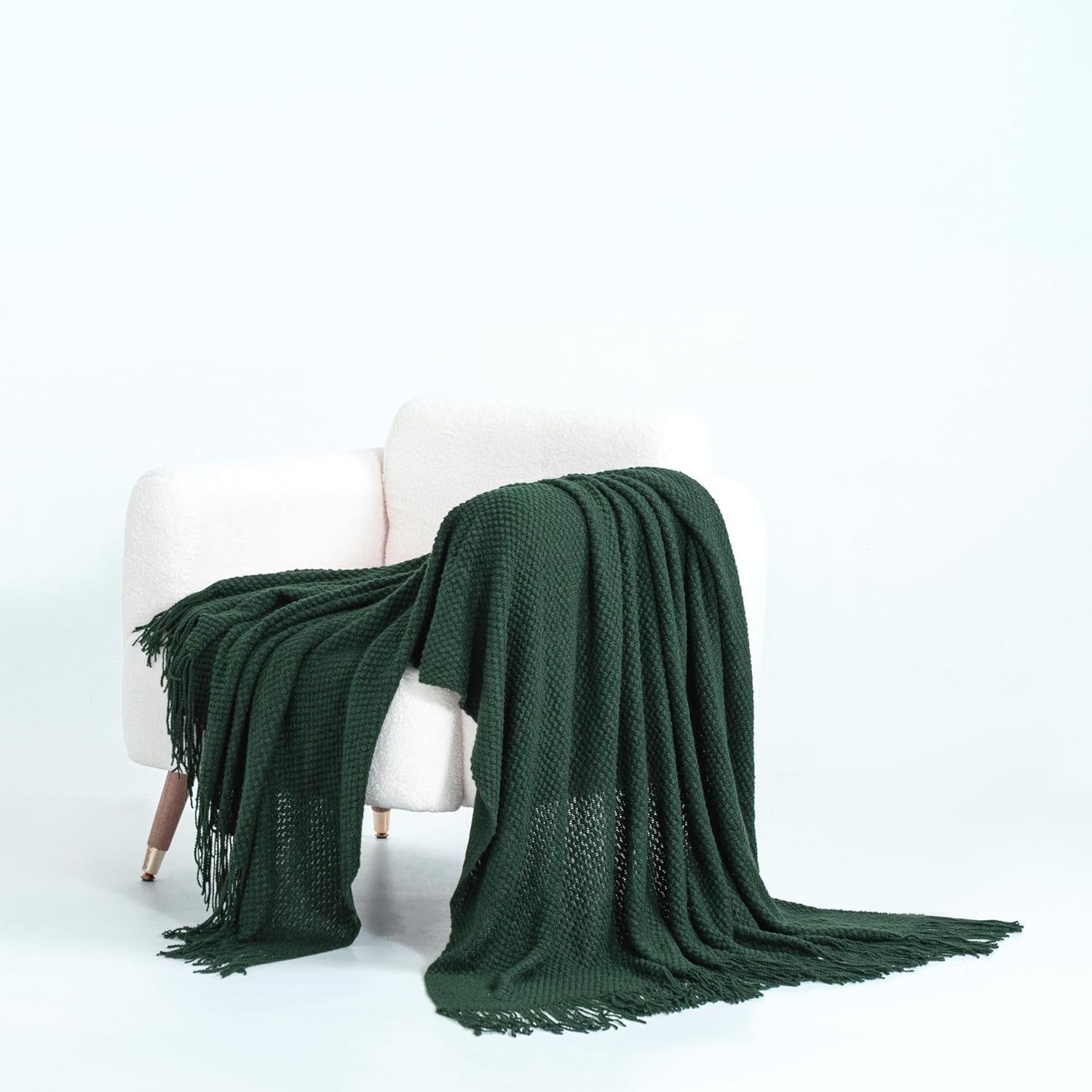 Forest green micro plush knitted woven throw blanket on a white chair, showcasing cozy and elegant design for couches, sofas, and beds.