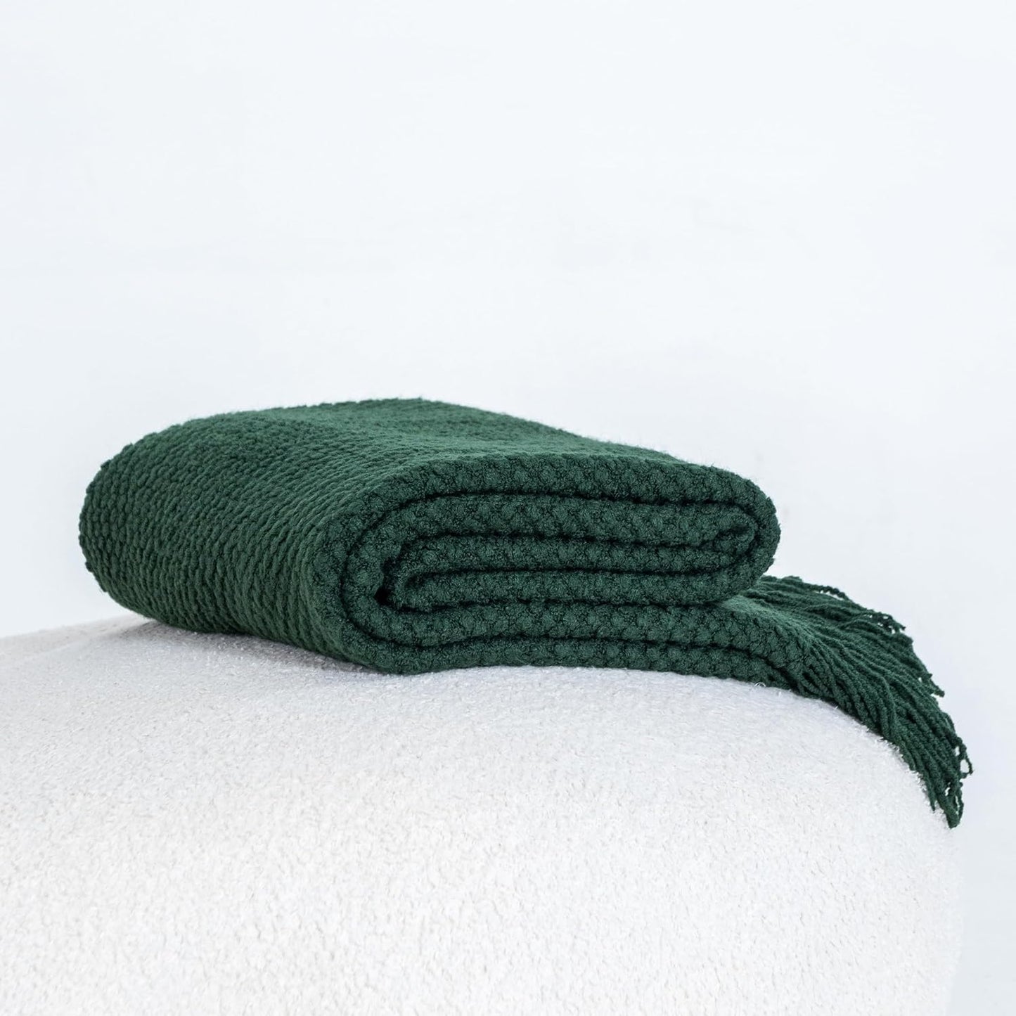 Forest green micro plush knitted throw blanket adding warmth and style to a room, perfect for couch or bed decor.