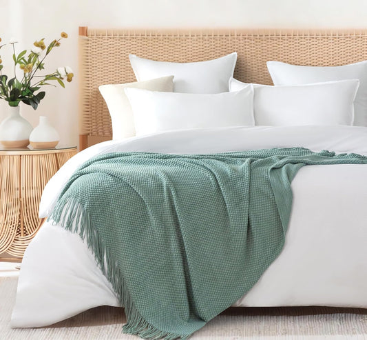 Seafoam micro plush throw blanket on bed with white pillows, adding cozy elegance to bedroom decor. Perfect for couches and sofas.