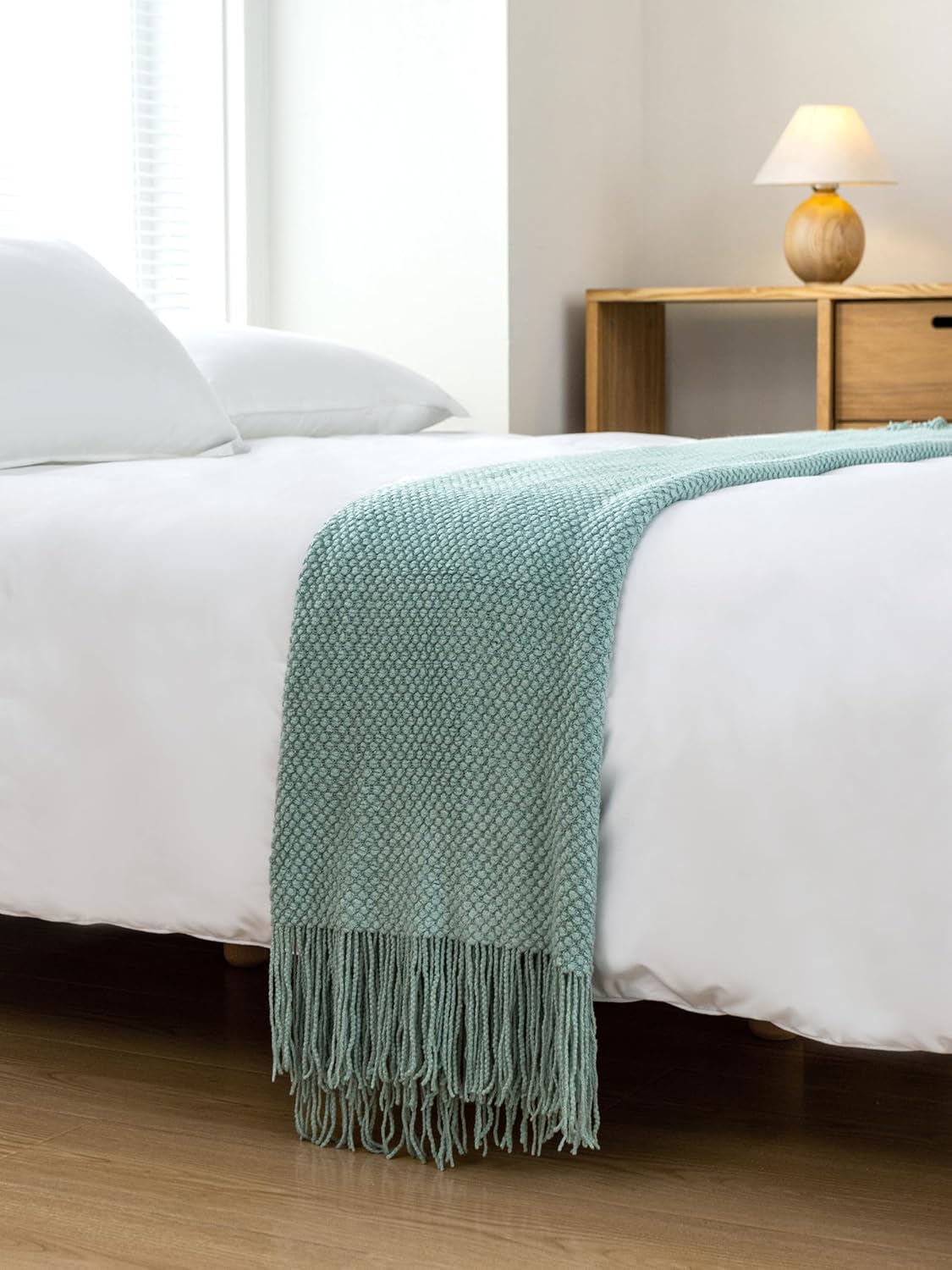 Seafoam Micro Plush Knitted Woven Throw Blanket draped over a bed, showcasing its cozy, luxurious design for ultimate comfort and warmth.