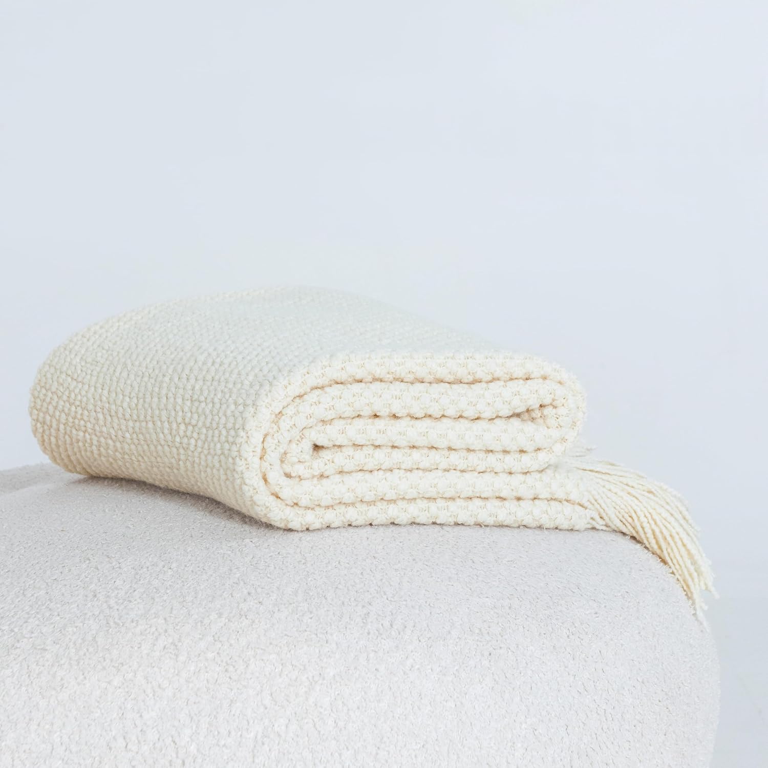 Cream snow-colored micro plush knitted woven throw blanket, perfect for cozy and elegant warmth, displayed folded.