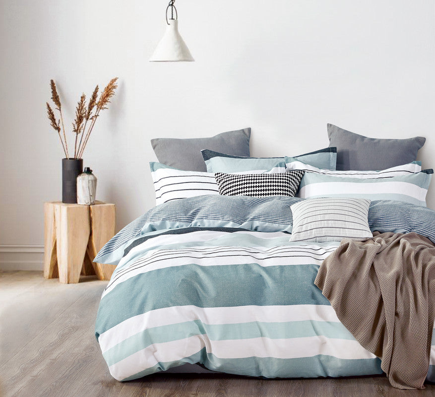 Striped cotton quilt cover set on a bed with decorative pillows, showcasing a cozy and stylish bedroom decor.