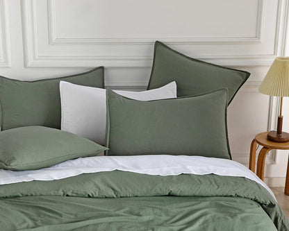 Vintage washed microfibre European pillowcases in khaki green and white on a cozy bed setup.