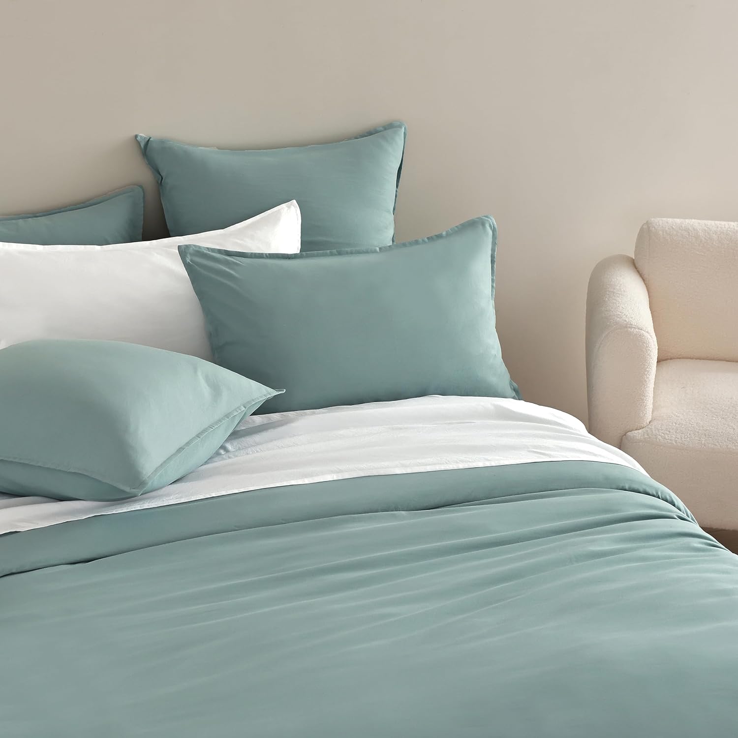 Luxurious vintage washed microfibre European pillowcases in seafoam color on a stylish bed setup.