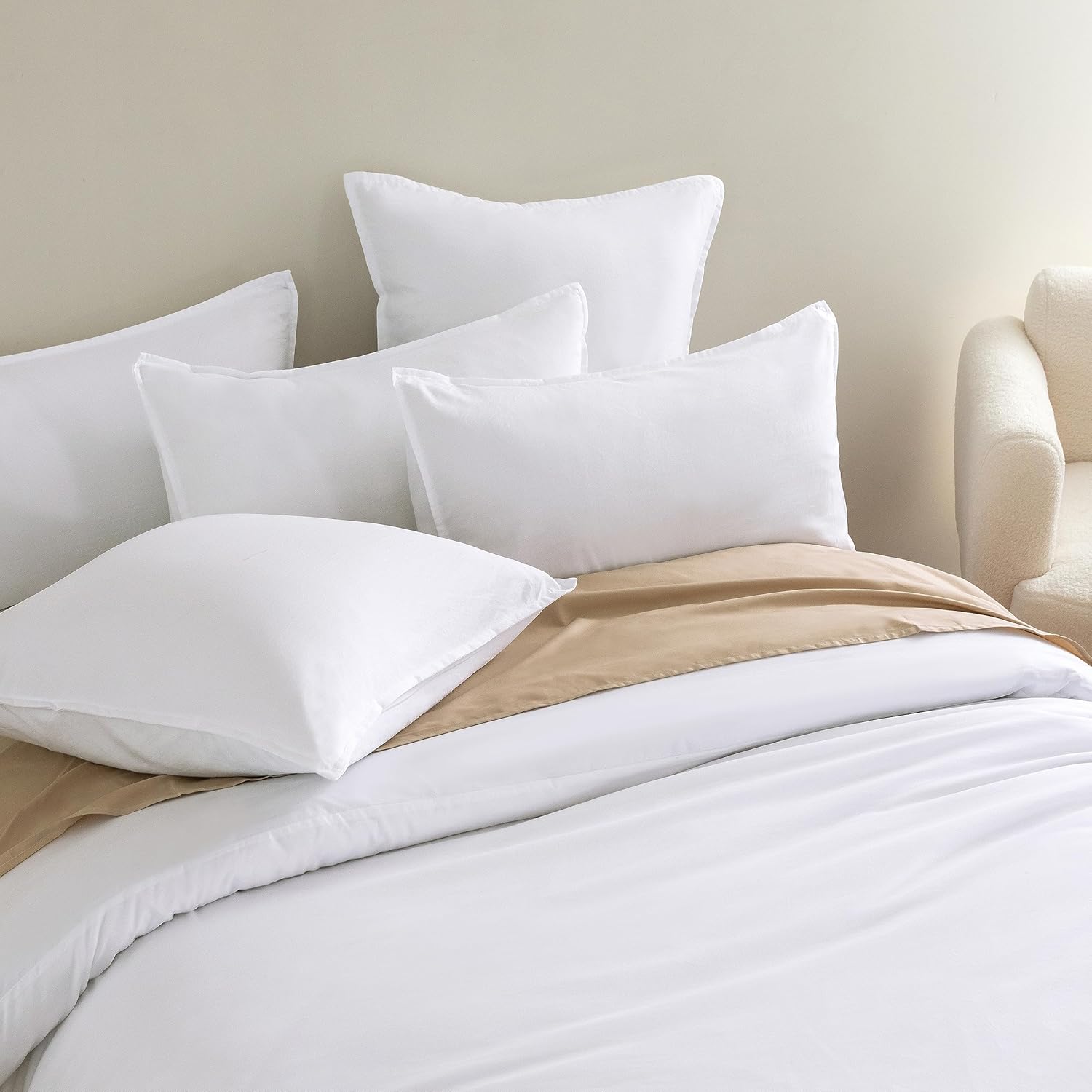 Luxurious white pillowcases elegantly arranged on a bed with soft bedding, showcasing vintage washed microfibre texture.