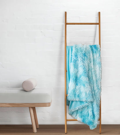 Blue double-sided faux fur throw blanket on decorative ladder, showcasing plush shaggy texture. Perfect luxury throws and blankets for warmth.