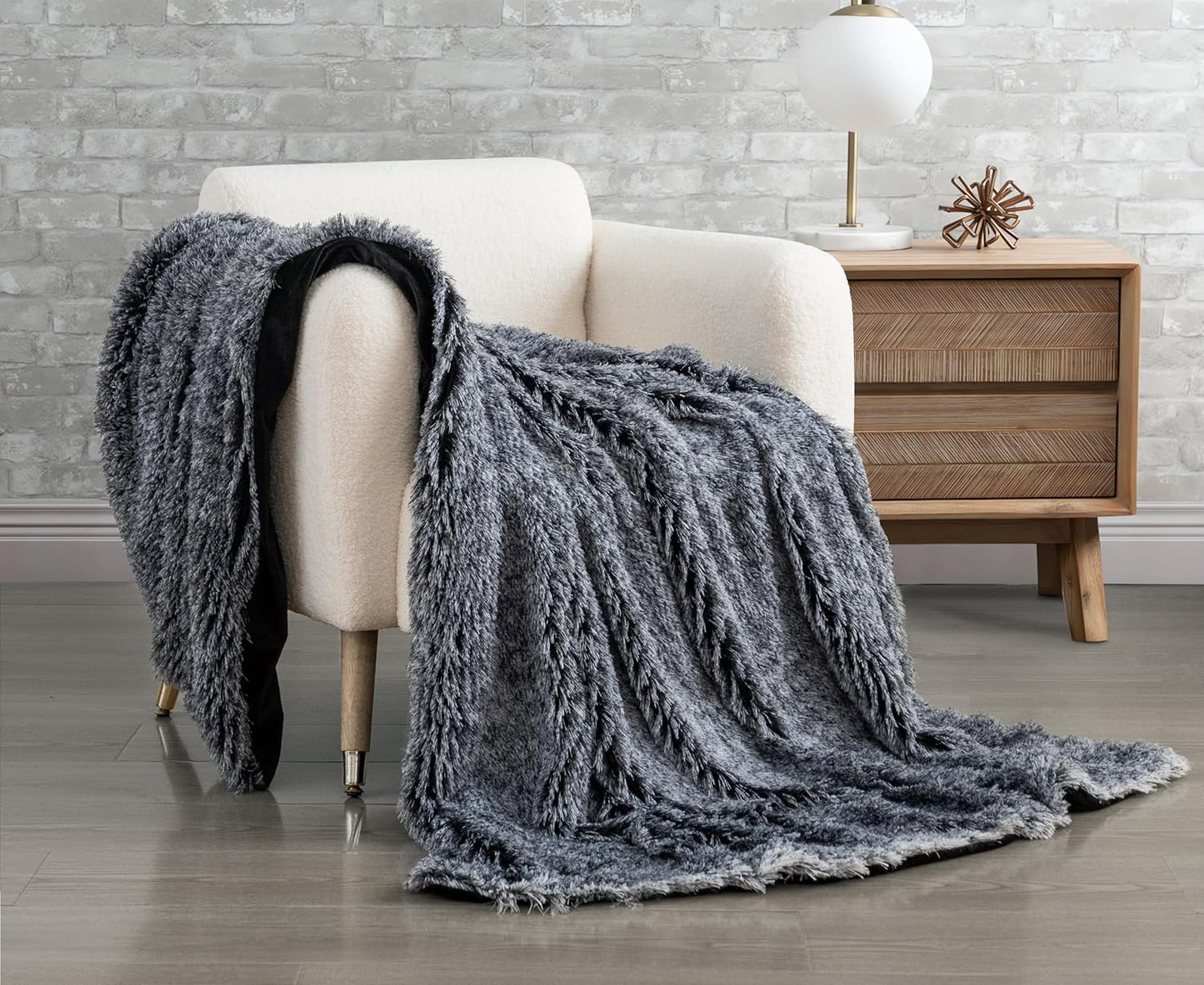 Charcoal faux fur shaggy throw blanket draped over a chair, showcasing plush double-sided texture; luxurious home throws and blankets.