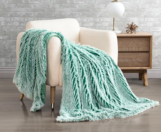 Emerald double-sided faux fur shaggy throw blanket draped over a beige armchair, adding a touch of luxury and warmth to the decor.