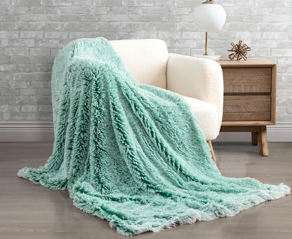 Emerald faux fur shaggy throw blanket draped over a cream chair, adding luxury and warmth to a cozy room setting.